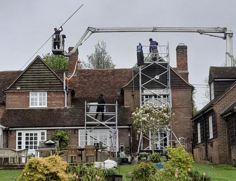 The Moss Cleaners using cherry picker and scaffolding to clean roof safely and professionally in Ewell, Surrey